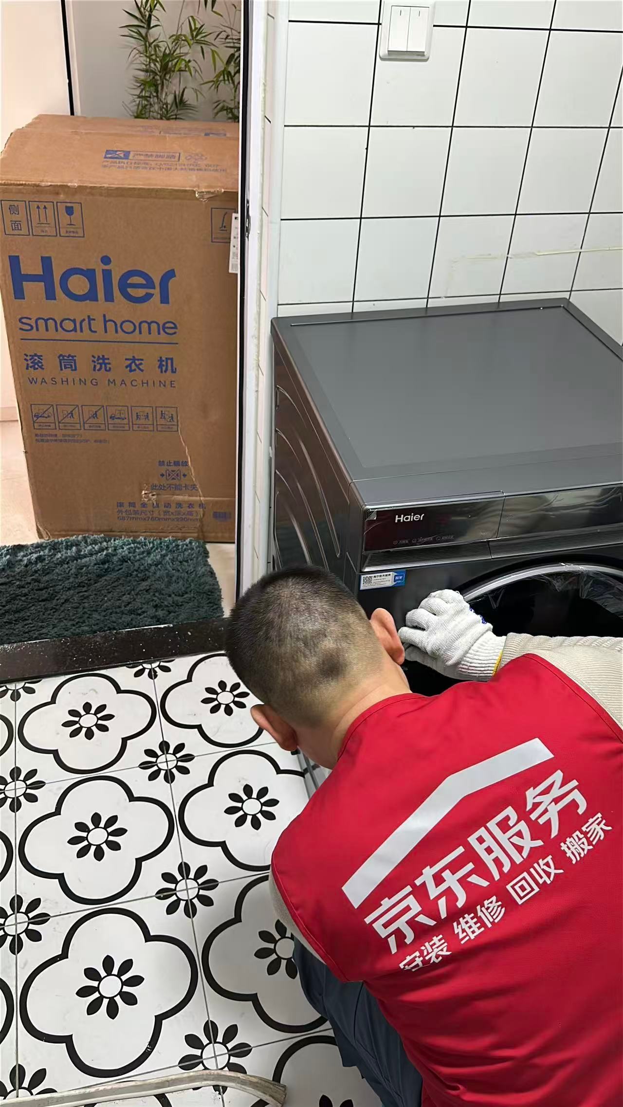A JD technician installs a Haier washing machine, with the brand’s box visible in the background. The image highlights the hands-on service that made the campaign popular.