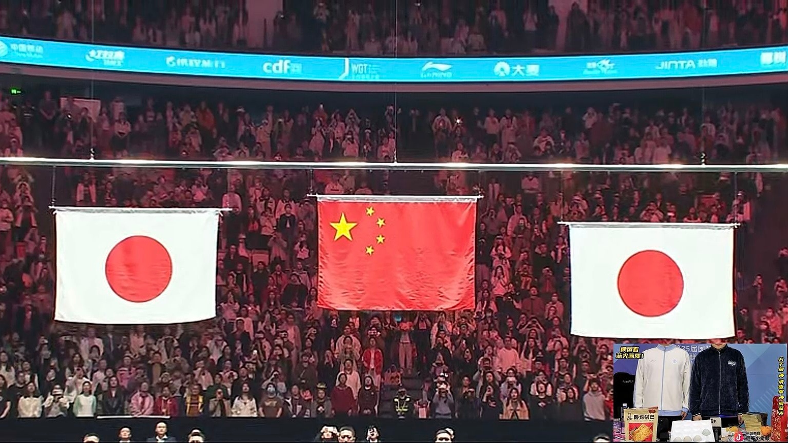 The flags of China and Japan hang above the court during the men’s singles final, symbolizing the intense rivalry between the two nations