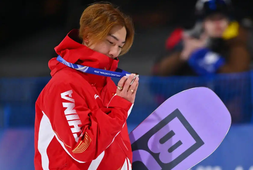 Su Yiming kisses his bronze medal after the men's big air snowboarding event at the 2026 Milan-Cortina Winter Olympics.