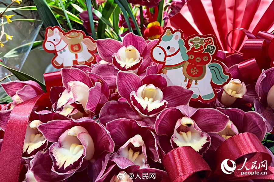Pink orchids decorated with small horse cutouts, symbolizing good fortune for the Year of the Horse.